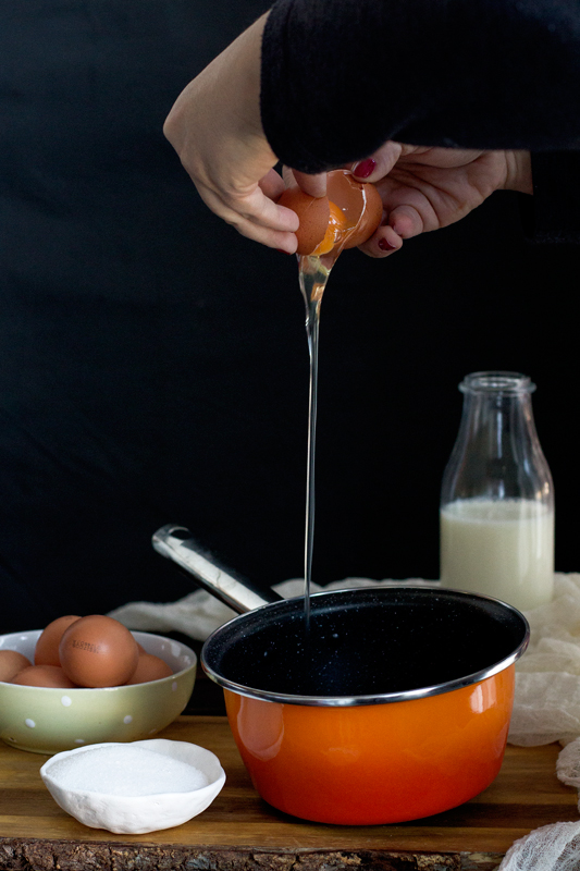 echando huevo en la crema pastelera para las berlinas rellenas de crema pastelera. receta paso a paso